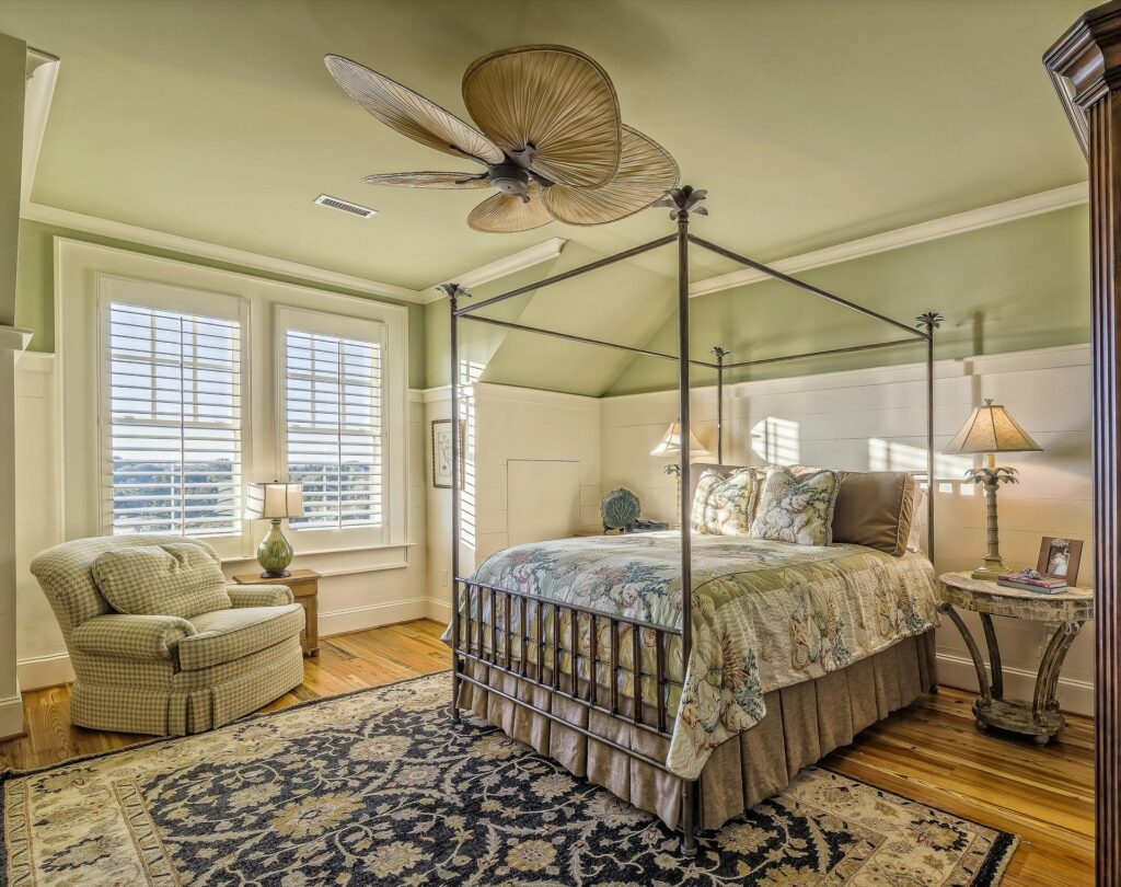 Quarto com parede em verde sálvia combinada com roupa de cama em linho e objetos de madeira