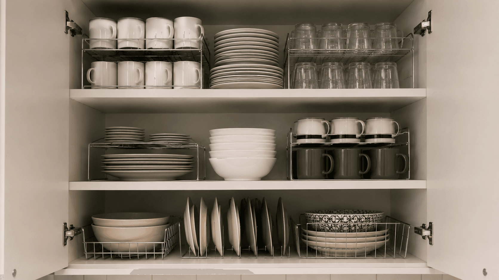 Cozinha Organizada: 10 Dicas Práticas para Transformar seu Espaço Armário de cozinha organizado com organizadores aramados empilhando pratos e xícaras