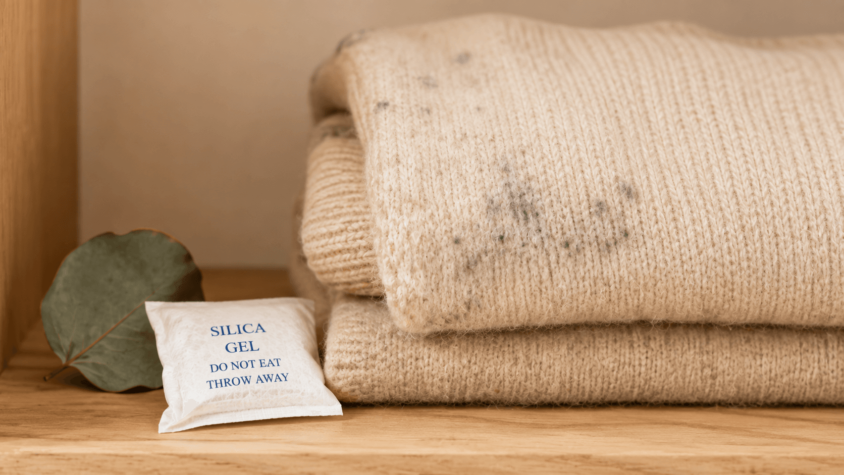 Guarda-Roupa Sem Mofo e Sem Traça: Guia Completo Roupa de lã com mancha de mofo ao lado de sachê de sílica gel
